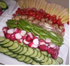 Example of a vegetable tray with cucumbers, radishes, snap peas, mushrooms, grape tomatoes, and baby corn