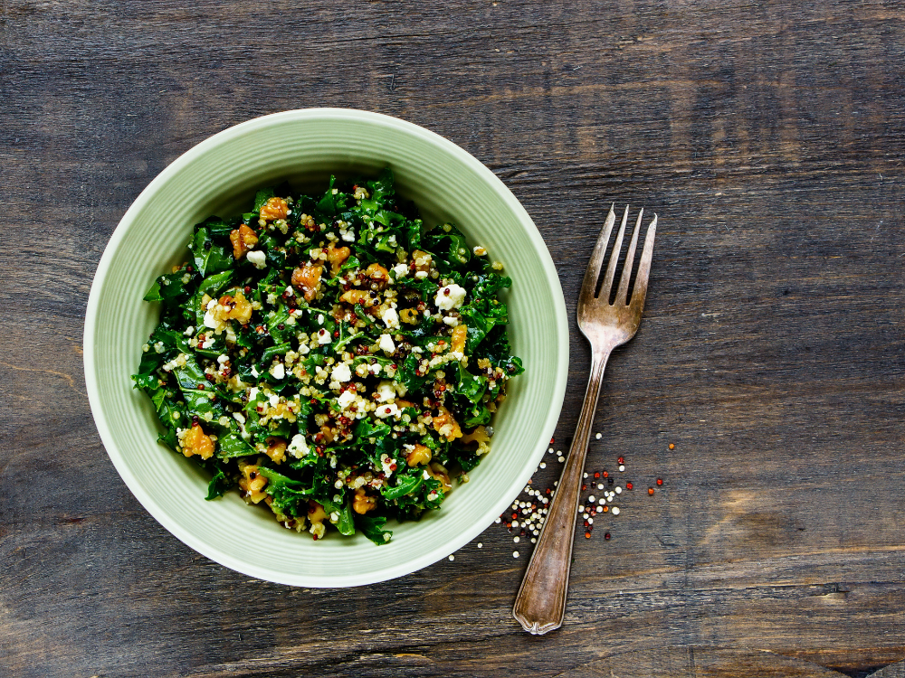 A colorful salad composed of curly kale leaves and fluffy quinoa grains.